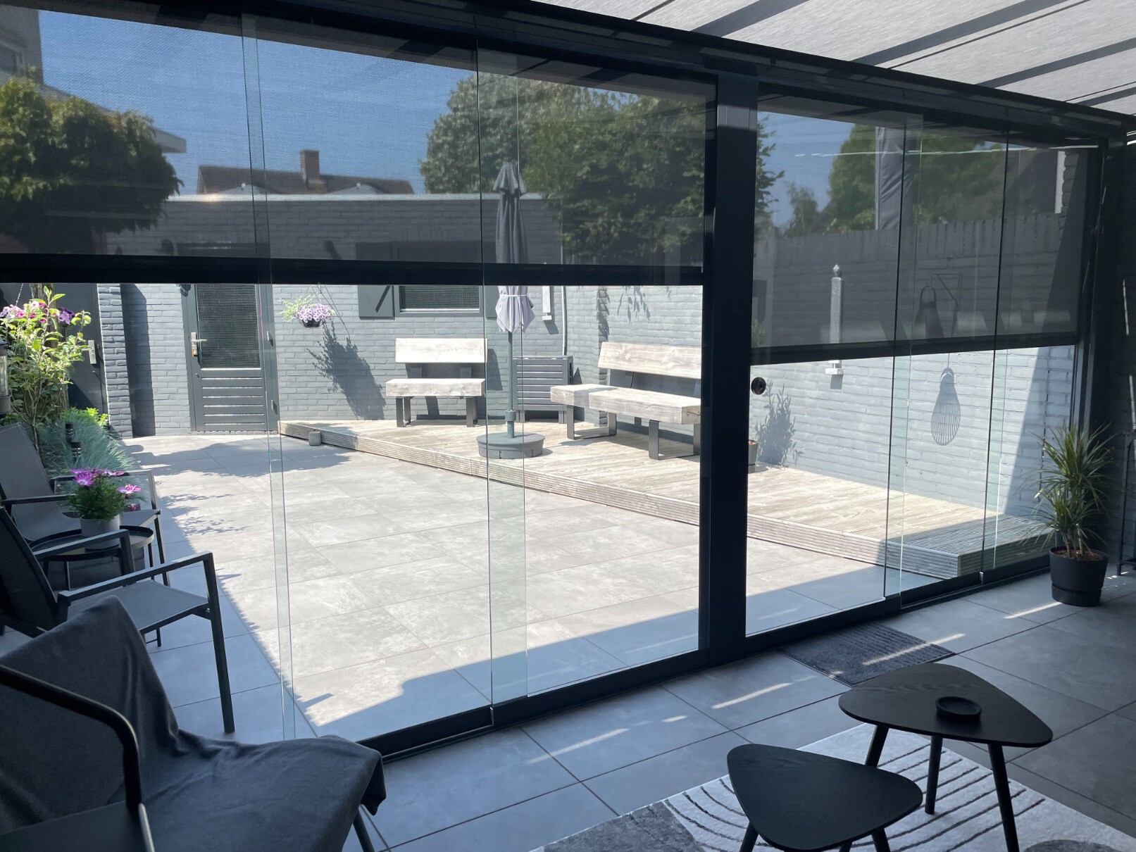 Fiësta terrasoverkapping met screens als zonwering bij een licht terras.